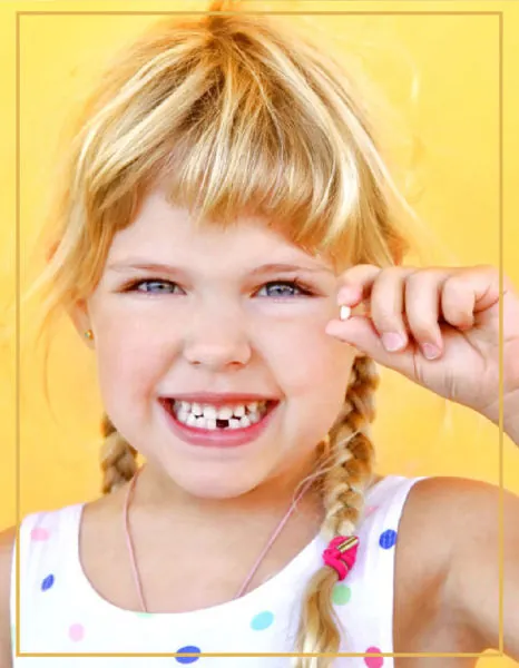 Smiling young girl with missing baby teeth